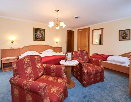 Dreibettzimmer mit Doppelbett, Einzelbett und Wohnbereich