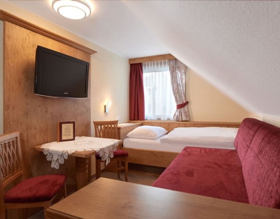 Dreibettzimmer mit separatem Wohnbereich mit Flat-TV